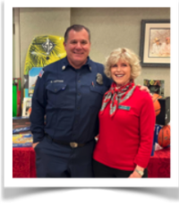 Jane Leary and paramedic Luther standing in front of a table of our toy drive donations