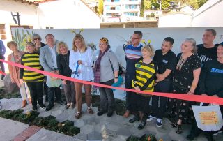 Mayor Kempf cutting the ribbon a the bee mural ribbon cutting ceremony