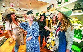 Image from Indy article with Ladies of Laguna trying on hats for the Get & Garden Tour.
